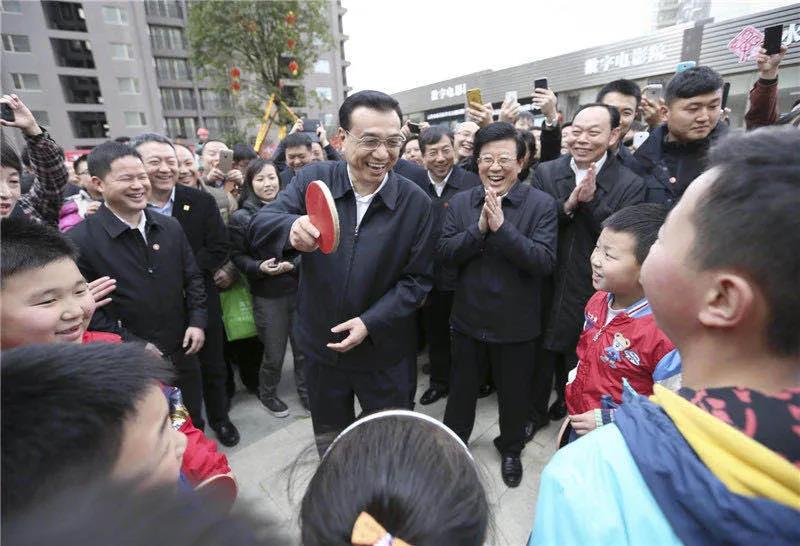 圖為李克強在貴陽考察時，一群孩子圍住總理“邀約”打乒乓球。